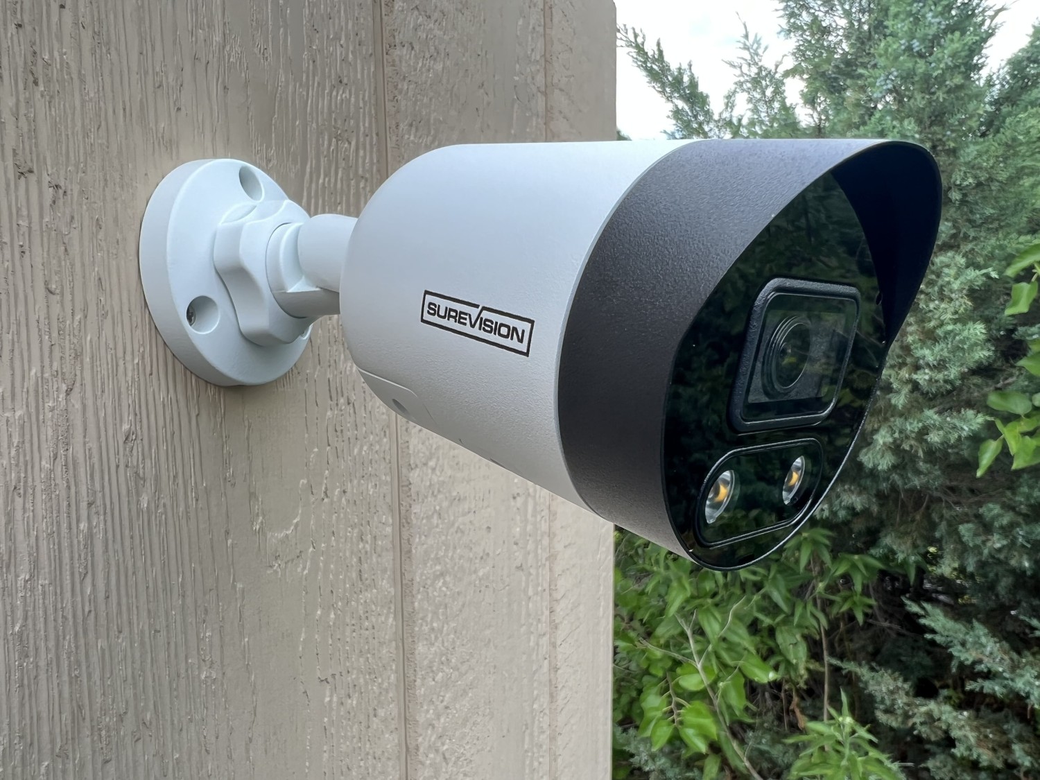 surveillance camera and illuminated light under a blue sky